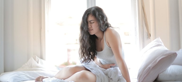 Woman in pain after liver damage from alcohol.