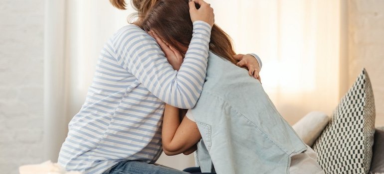 A mother and daughter hugging each other.