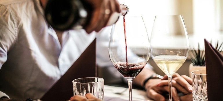 a person pouring a glass of wine 