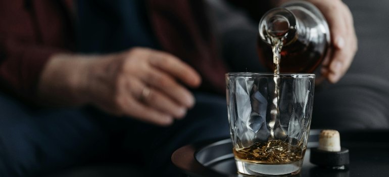 a person pouring a glass with alcohol wondering how long does it take alcohol to leave your system