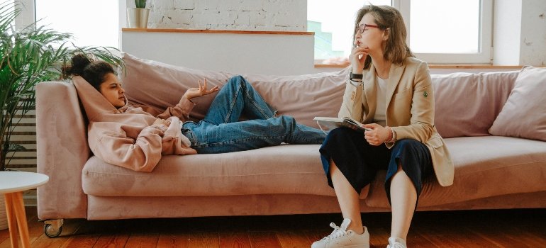 A girl laying on a couch while talking to a therapist