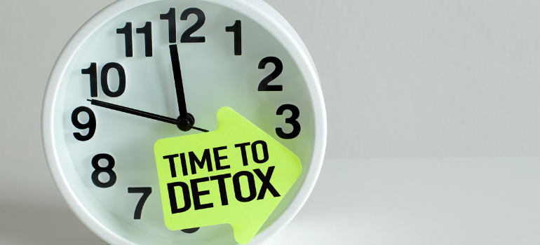 A watch with a post it note that says time to detox 