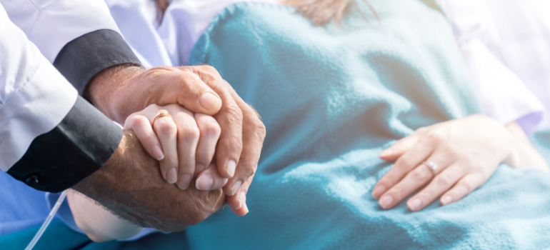 A doctor holding his patient's hand while they are in recovery from methadone withdrawal symptoms 