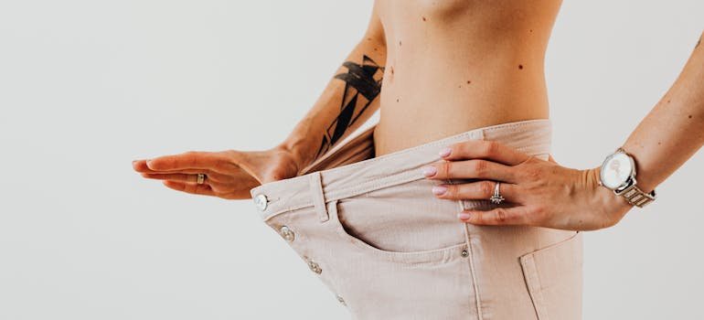 Woman pulling her pants to show off her weight loss wondering what does cocaine do to your body