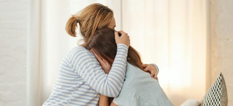 Mother hugging her daughter.