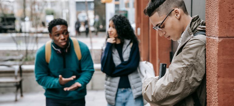 Teens peer pressuring and teasing a boy.