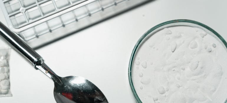 Spoon next to a container with heroin.