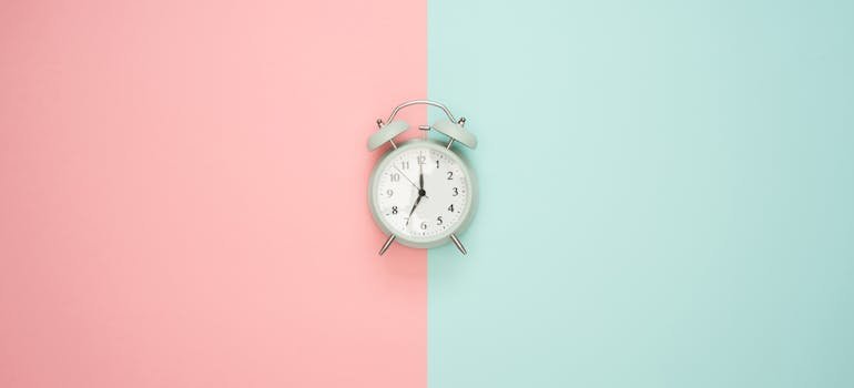 alarm clock in front of a pink and blue background