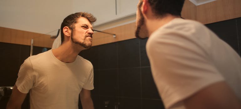 a young man looking at himself in the mirror