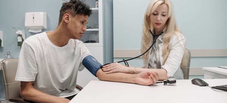 Doctor measuring a patient's high blood pressure and talking about what does cocaine do to your body.