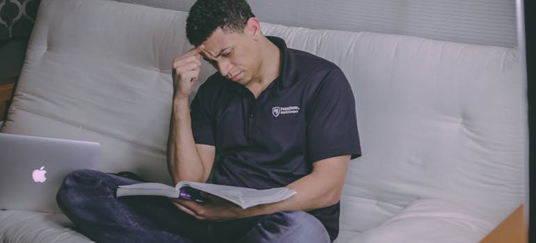 Man holding his head in confusion and reading a book about heroin vs. cocaine