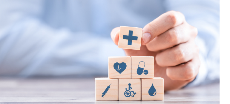 A hand arranges wooden blocks that have icons representing health symbols in them