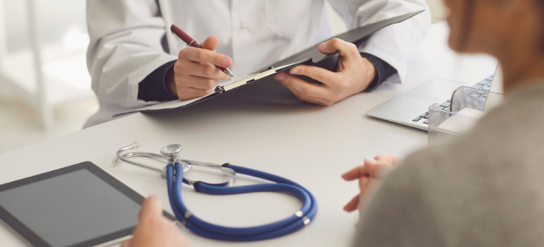 The hands of a doctor and his patient talking about effects of heroin on the brain
