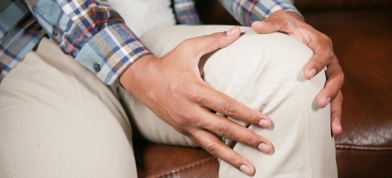 a man in pain holding his knee 