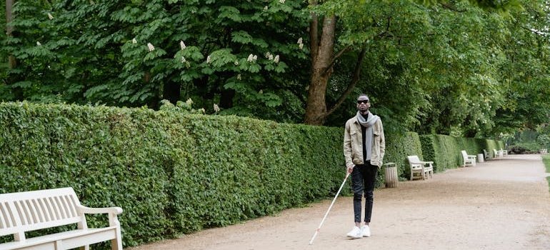 Blind man walking with a cane.