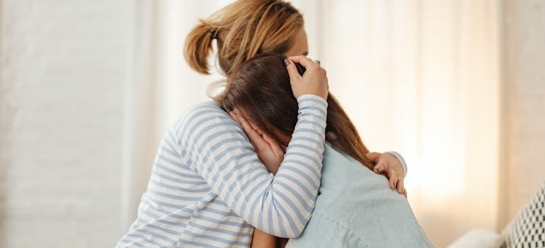 Woman hugging her daughter while they fight alcoholism and the impact alcohol has on your eyes.