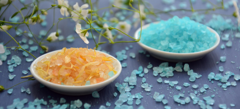 Exploring the dangers and realities of bath salts: Powdered colored substances, one yellow and one blue, in small glass containers