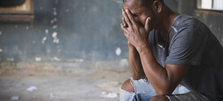 A young man in the street with broken jeans and a stained t-shirt cries in the corner wondering how long does percocet stay in your system