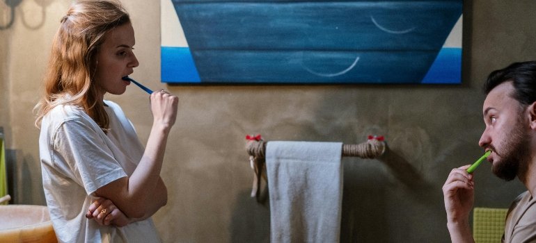 A man and a woman brushing their teeth