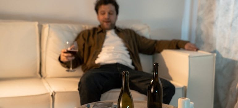 Man sitting on the couch and drinking wine.