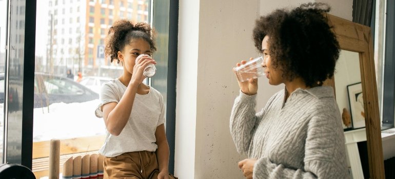 A woman and her daughter drinking water
