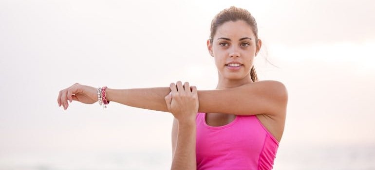 Woman in pink top stretching.
