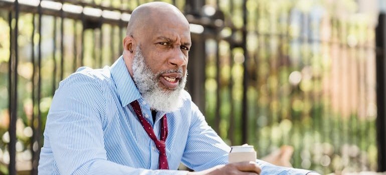 Man holding a beer can with an angry expression.