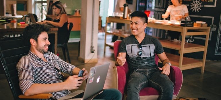 Two friends sitting at a caffe and talking.