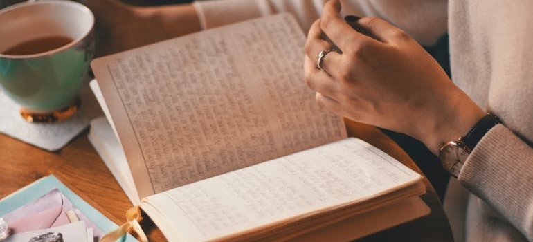 Woman journaling about alcohol cravings and drinking tea