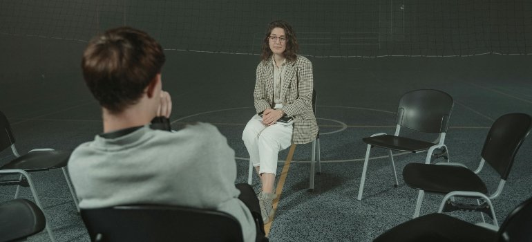 A man and a woman talking in group therapy for alcohol addiction