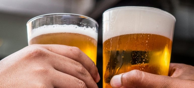Two people are cheering with two glasses of beer.