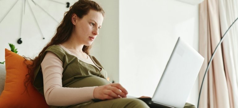 A pregnant woman is searching for fetal alcohol syndrome statistics on her laptop.