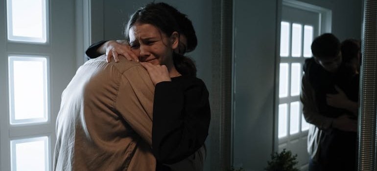 Woman crying and hugging her friend.