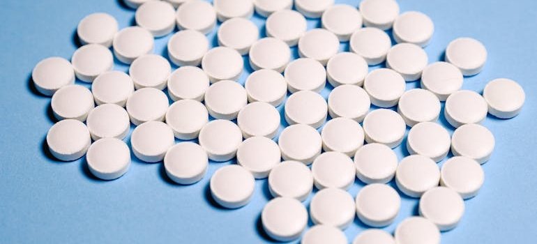 Cluster of white tablets on a blue background.