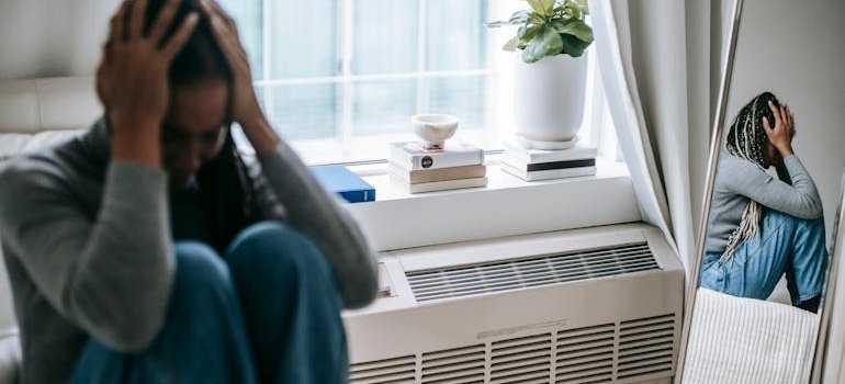 Woman sitting on her bed and experiencing an anxiety attack.