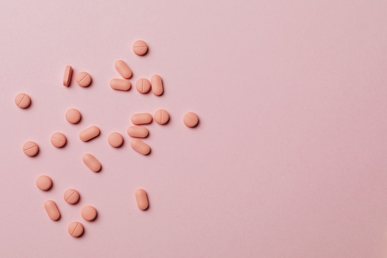 Pink pills on a pink background.