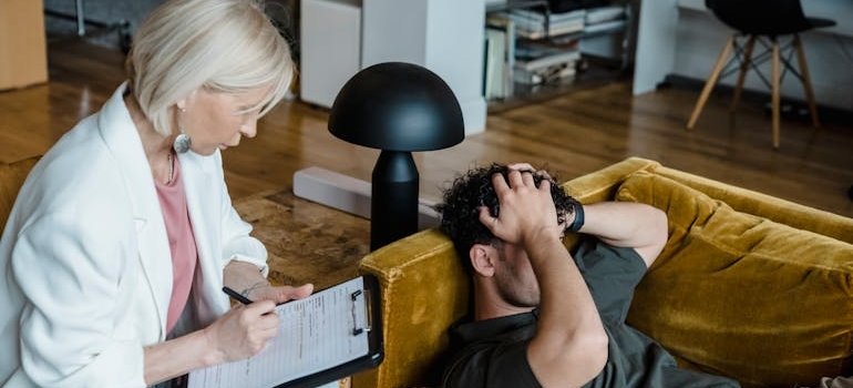 Man holding his head and talking to a therapist.