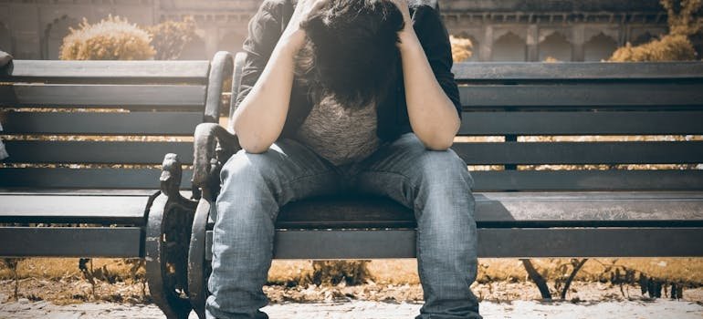 Man sitting on a bench and struggling with cocaine and depression.