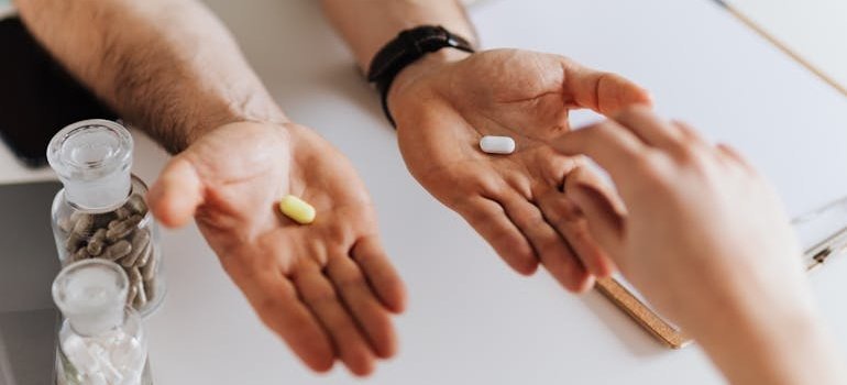 Doctor handing our Restoril and Melatonin pills to a patient.