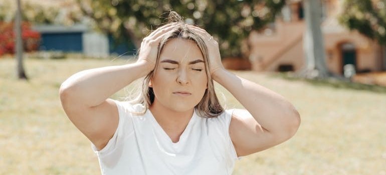 Woman holding her head in her hands while worrying about can meth cause mental illness.