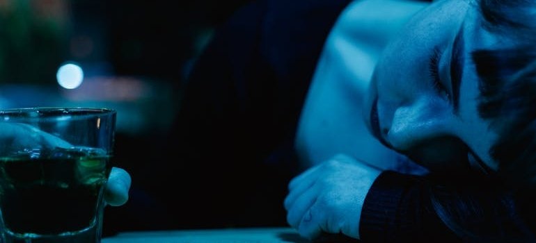 Woman lying on her arm and drinking whiskey.