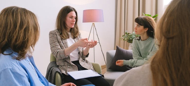 Therapist talking to a group of people attending family therapy in addiction treatment.