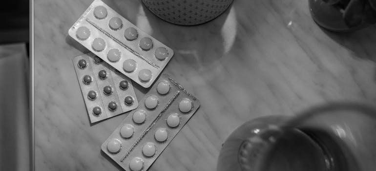 Three blisters of pills on a nightstand.