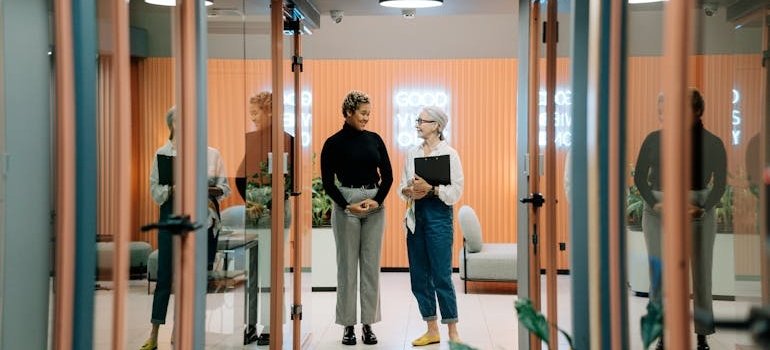 Woman walking around the office with her boss.