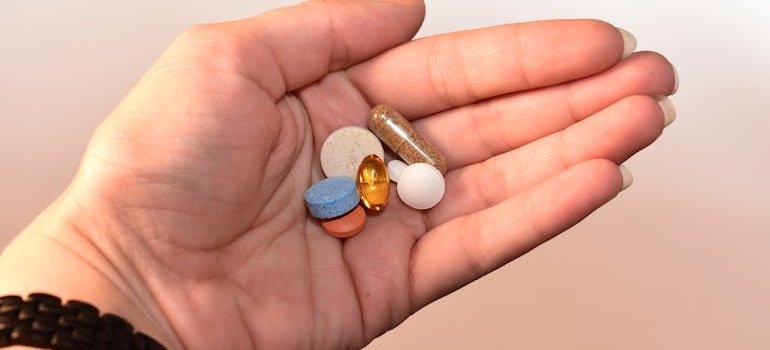Person holding different pills in their hand.