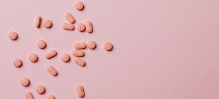 Pink pills on a pink background.