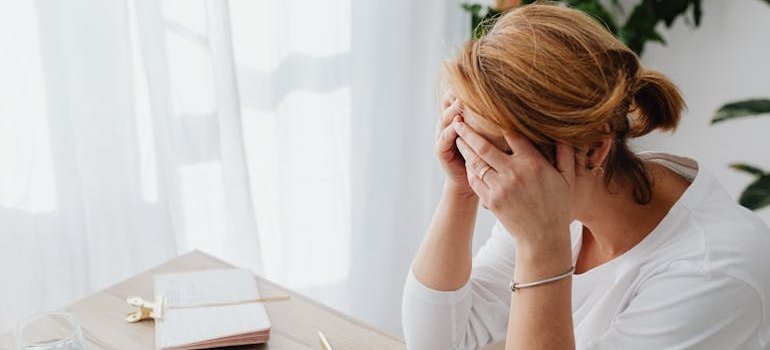 Woman crying while thinking about her issues with alcohol abuse and poverty.