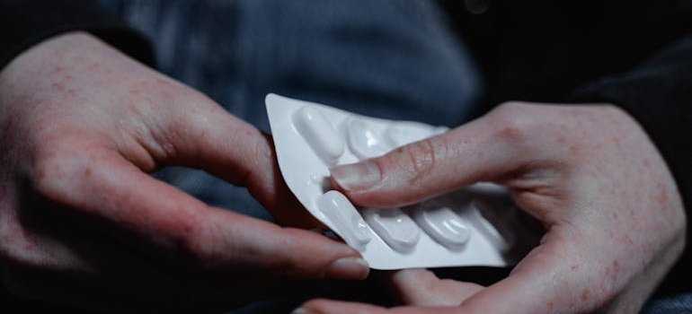 Person pushing a pill out of its blister.
