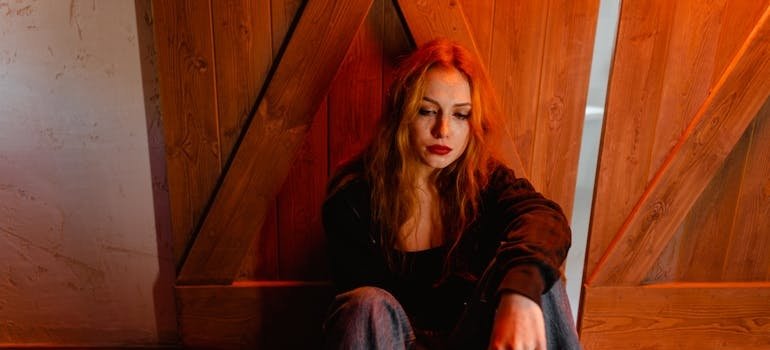 Woman leaning against a wall while experiencing Lexapro withdrawal symptoms.