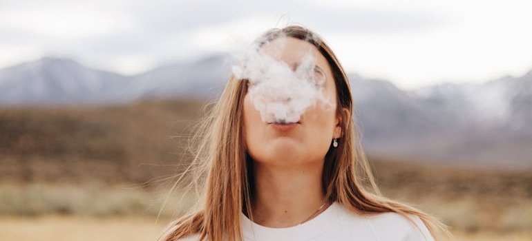 Woman blowing smoke.